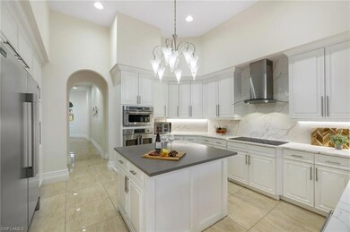 Kitchen featuring wall chimney range hood, white c