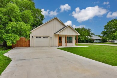 View of front of property with a front lawn, a gar