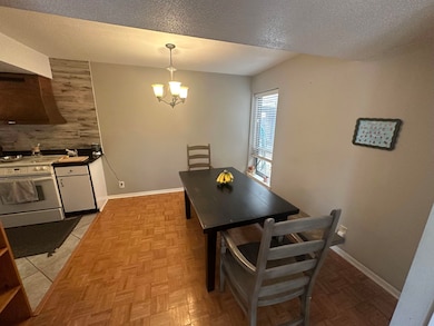 Dining space with a chandelier, a textured ceiling, and baseboards