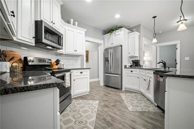 Kitchen featuring appliances with stainless steel finishes, a sink, white cabinets, tasteful backsplash, and recessed lighting