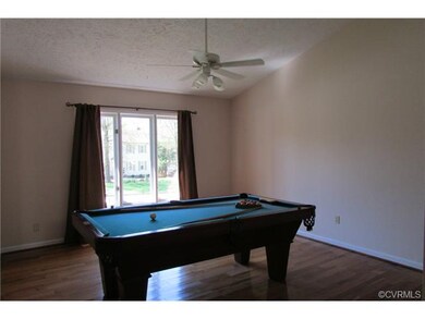 Living room with vaulted ceiling and wood floors.