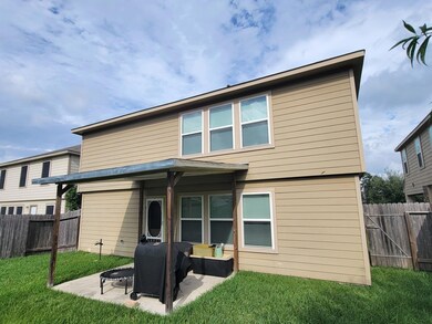Rear view of property featuring a lawn and a patio