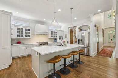 The Chef's Kitchen is a true showpiece outfitted with a Wolf Range and Custom Hood, Quartzite Countertops, Double Oven, Butler's Pantry, Wine Cooler, and a Statement Island for gathering.