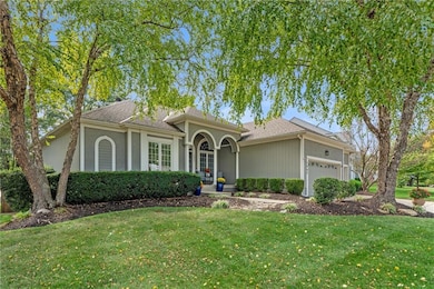 View of front of property with a front lawn, an attached garage, and a shingled roof