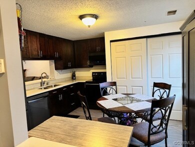 Kitchen with a textured ceiling, light hardwood /