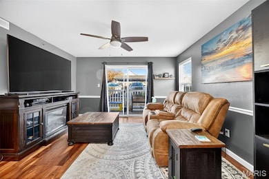 Living room with dark wood-style floors and ceiling fan