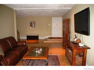 Living room with wood parquet floor, open to foyer