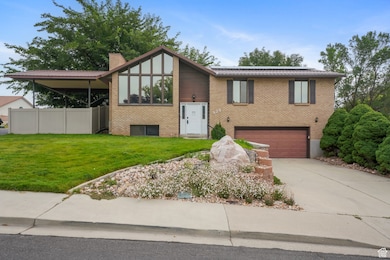 View of front of property with driveway, brick siding, and a garage