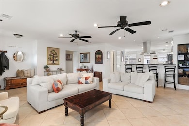 Living room view highlighting the open concept of the eat-in bar, kitchen and rear entrance