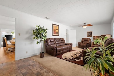 Living area featuring visible vents, ceiling fan, 
