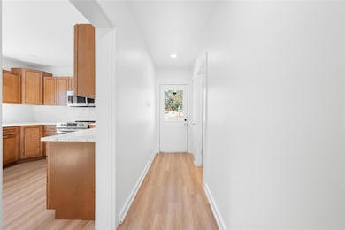Hall with light wood-style flooring and recessed lighting