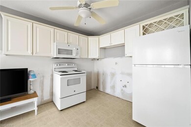 Kitchen featuring ceiling fan, white cabinetry, wh