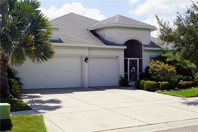 Three Car garage and decorative screen door with plush landscaping