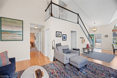 Living room featuring an inviting chandelier, high vaulted ceiling, and hardwood / wood-style floors