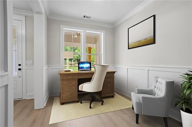 Office area with light wood-style floors, ornamental molding, a wainscoted wall, a decorative wall, and a chandelier