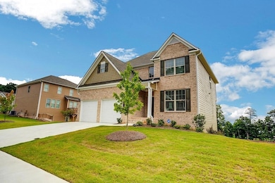 Craftsman inspired home featuring a front yard, brick siding, and concrete driveway