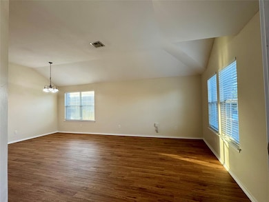 Spare room featuring lofted ceiling, a chandelier