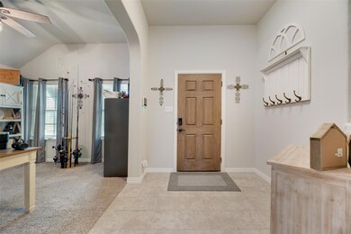 Carpeted foyer featuring lofted ceiling and ceilin