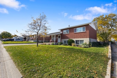 Split level home with a front lawn, brick siding, and covered porch