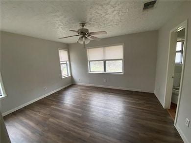 Empty room featuring dark wood-style floors, a ce