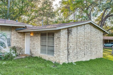 View of side of home with a lawn and stone siding