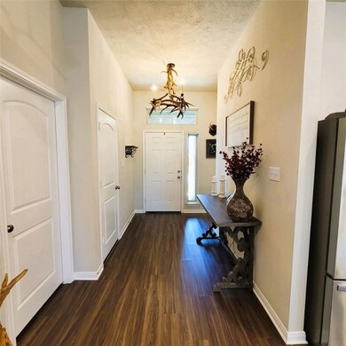 Entrance foyer with a textured ceiling, wood finis