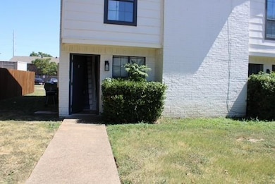 Doorway to property featuring a yard and fence