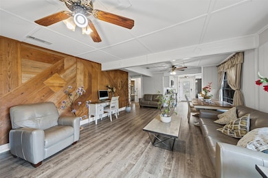 Living area with wooden walls, wood finished floo