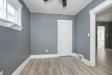 Spare room featuring light hardwood / wood-style floors, a textured ceiling, crown molding, and ceiling fan