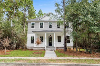 View of front facade featuring a porch, a front lawn, board and batten siding, and roof with shingles