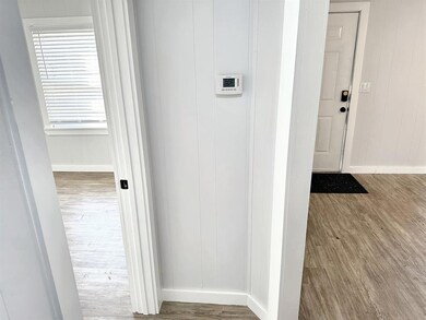 Hallway with hardwood / wood-style floors