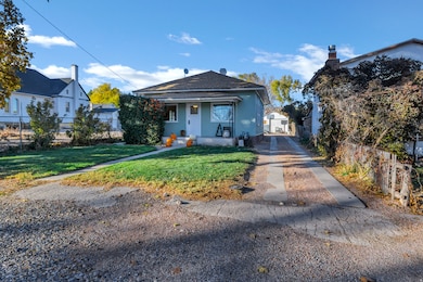View of front of house featuring a shingled roof, stucco siding, covered porch, and a chimney