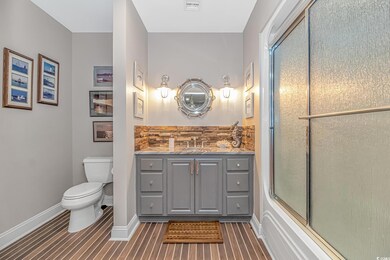 Full bathroom with toilet, vanity, and baseboards