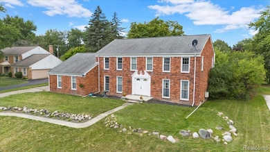 Colonial-style house with brick siding and a front yard