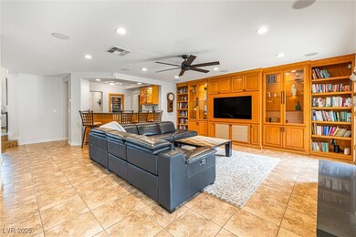 Living area featuring light tile patterned floors, recessed lighting, built in shelves, and a ceiling fan