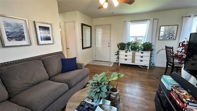 Living room featuring ceiling fan and dark hardwoo