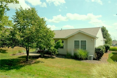 View of side of home featuring central air condition unit and a lawn