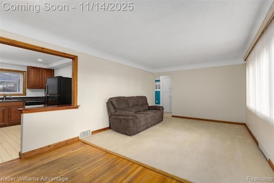 Living area with light wood finished floors and light colored carpet