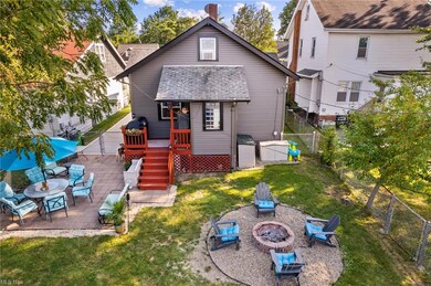 Rear view of property featuring a yard, an outdoor firepit, and a patio