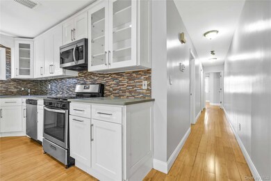 Kitchen featuring light wood-style floors, stainless steel appliances, tasteful backsplash, and visible vents