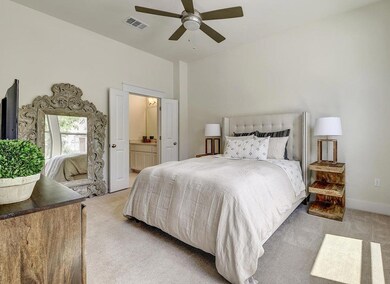 Bedroom with ensuite bath, a ceiling fan, visible