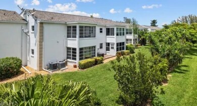 Rear view of property featuring a lawn and stucco siding