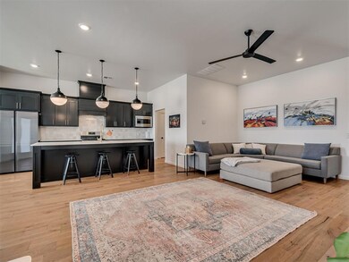 Living room with a ceiling fan, light wood finished floors, recessed lighting, and baseboards