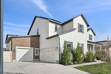 View of side of home featuring board and batten siding, driveway, and brick siding