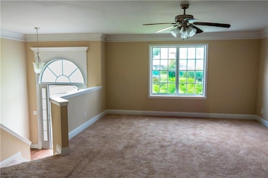Carpeted empty room with crown molding, baseboards, and a ceiling fan