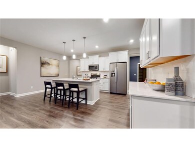 This dream kitchen features plenty of cabinet space, an oversized center island, quartz countertops, tile backsplash, walk-in pantry and the popular slate finish appliances! Photo of model home, colors and finishes will vary.