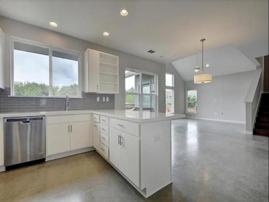 Kitchen with dishwasher, finished concrete floori