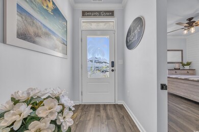 Entryway featuring wood finished floors, crown molding, baseboards, and a ceiling fan