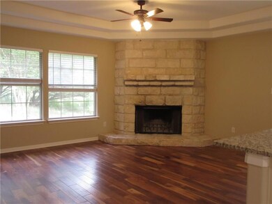 Living room with corner woodburning fireplace and trayed ceilings!