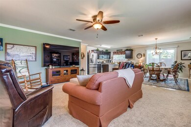 Living Room with Crown Molding Open to the Dining and Kitchen
